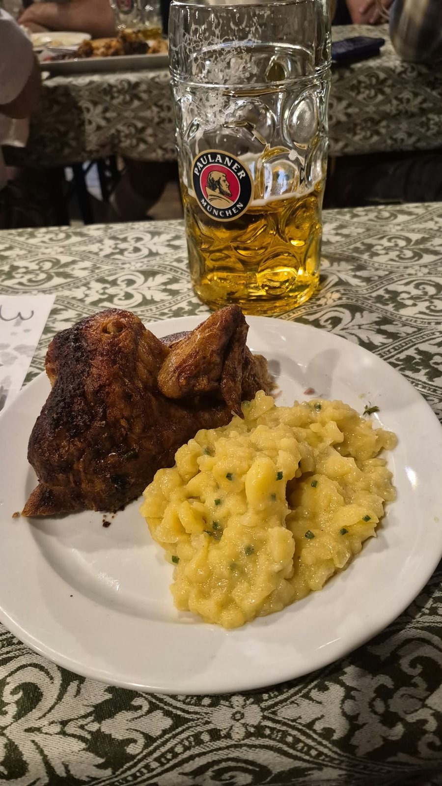 Brathendl, frango assado com salada de batata, e caneca de cerveja
